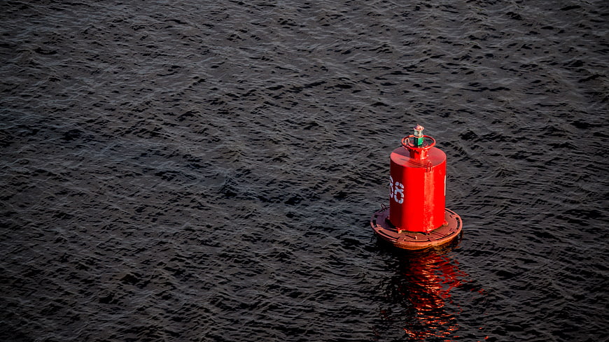 Red Navigation Buoy Floating in Dark Water