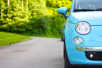 Close-up of a light blue Fiat 500L parked on a paved path
