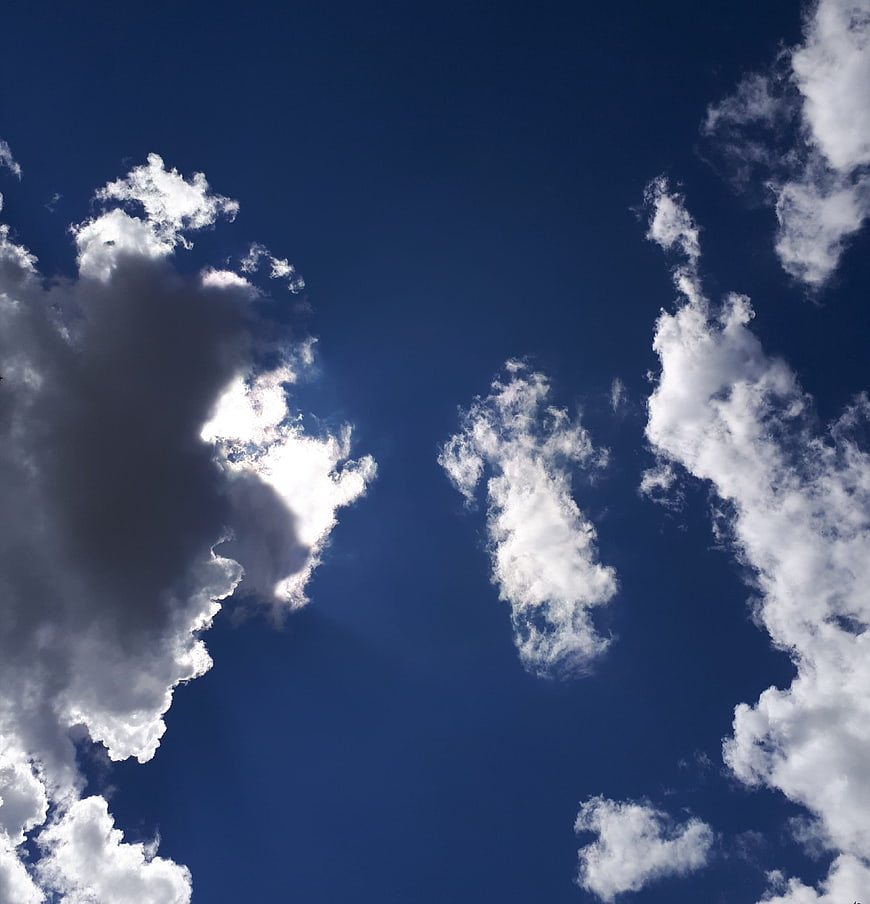 Dramatic blue sky with white clouds and sun rays