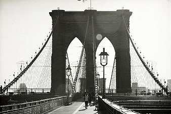 Black and white photo of Brooklyn Bridge arches and pedestrians