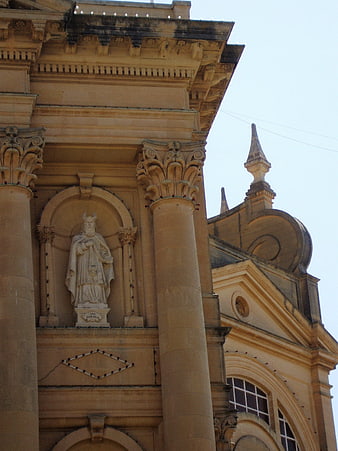 Baroque church facade with statue and columns in Malta