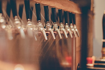 Close-up of beer taps in a dimly lit bar