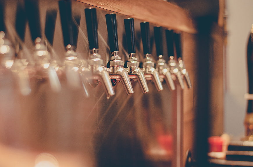 Close-up of beer taps in a dimly lit bar