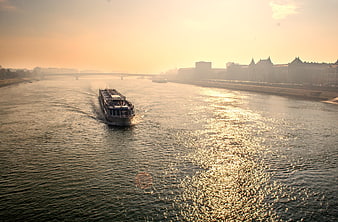 Cargo ship sailing on Danube river in Budapest at sunset