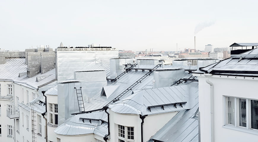 White urban rooftops with metal details and city skyline