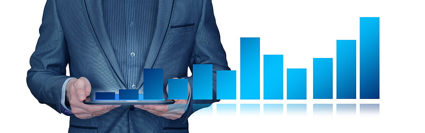 Businessman in suit holding tablet with blue bar chart graphic