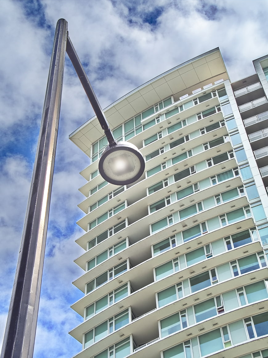 Low angle view of modern apartment building and street lamp