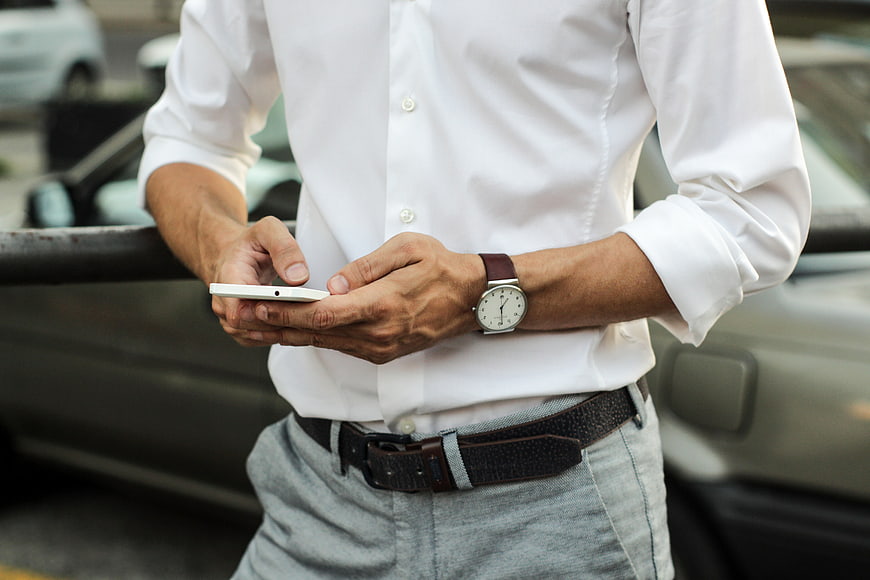 Man in White Shirt Using Smartphone with Wristwatch
