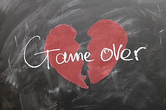 Broken red heart with game over text on chalkboard