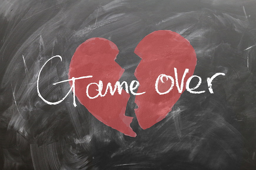 Broken red heart with game over text on chalkboard
