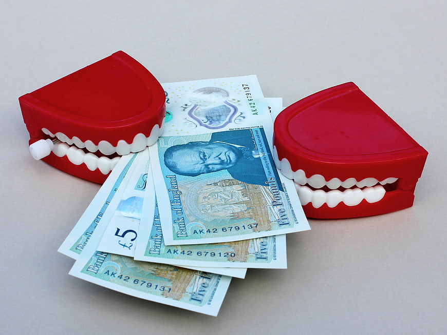 Chattering teeth toy biting British five pound banknotes