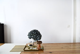 Minimalist wooden table with dried flowers and candles on tray