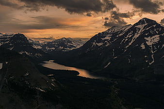 Dramatic Sunset Over Snowy Mountain Valley and Lake