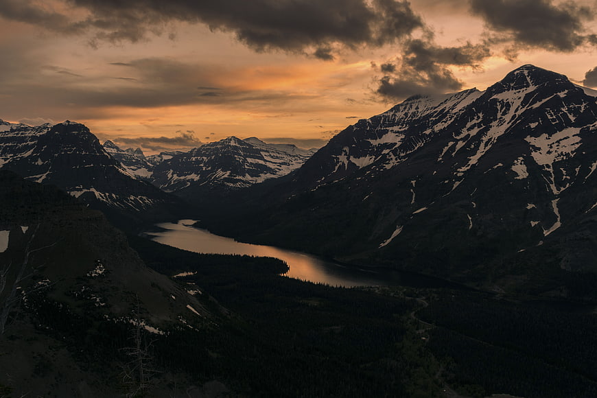 Dramatic Sunset Over Snowy Mountain Valley and Lake