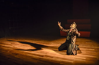 Male actor performing dramatic monologue on theater stage