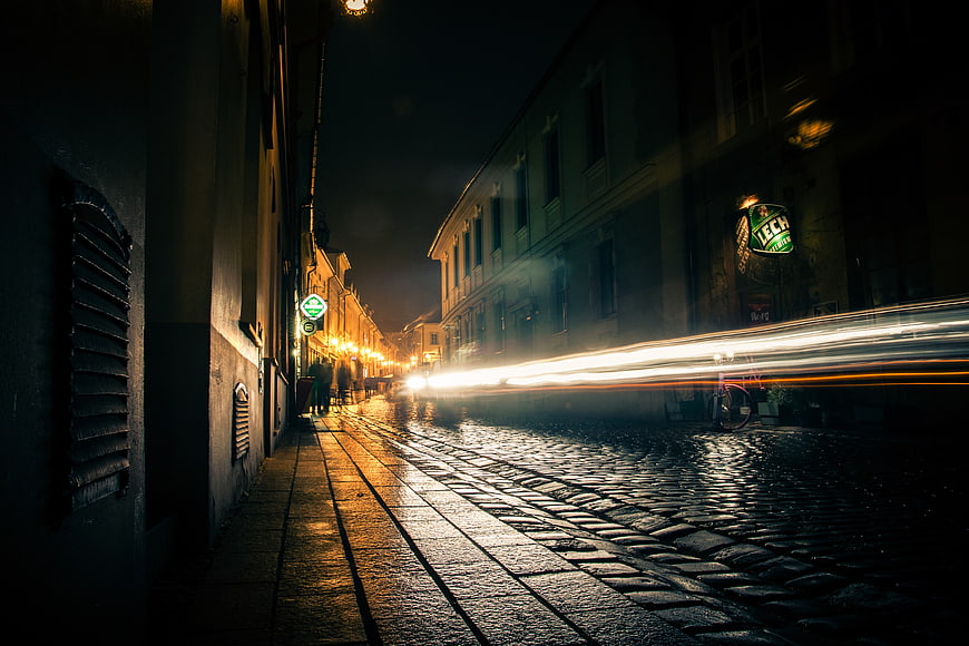 Long Exposure Night Street with Light Trails on Cobblestones
