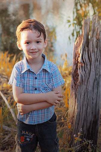 Cute little boy standing outdoors in golden hour light