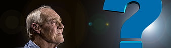 Senior man looking at large blue question mark symbol