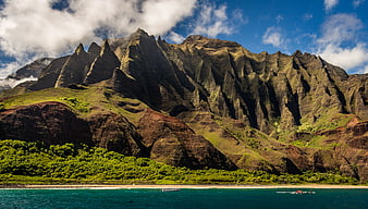 Dramatic jagged mountain peaks rising above a tropical turquoise coastline