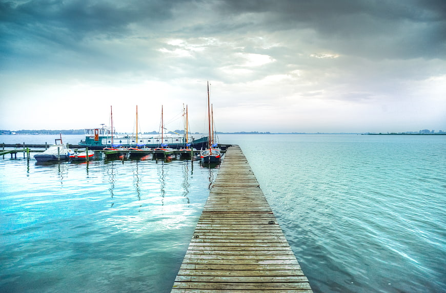 Wooden pier extending into calm turquoise harbor water