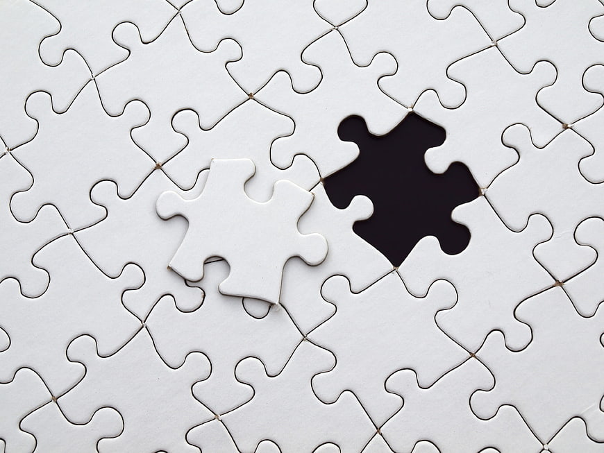 Missing white puzzle piece on blank jigsaw background