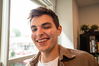 Close-up portrait of smiling young man indoors