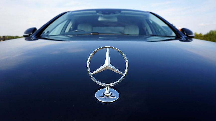 Close-up of Mercedes-Benz Hood Emblem on Blue Car