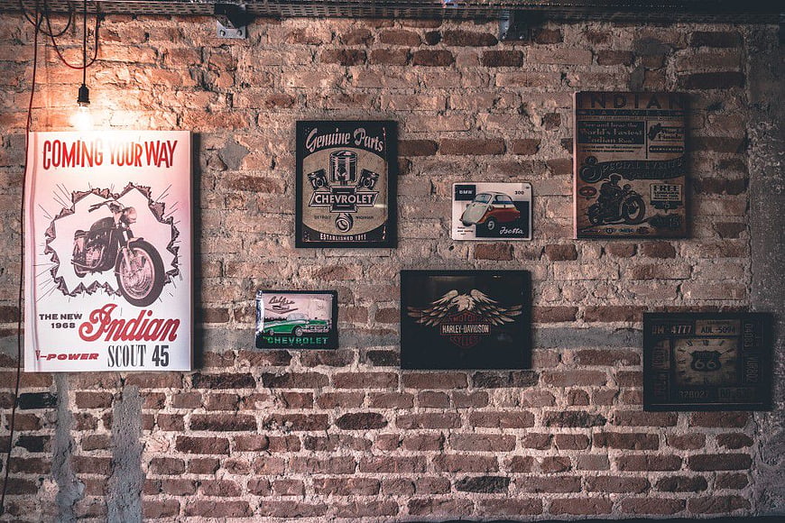 Vintage Motorcycle and Car Signs on Exposed Brick Wall