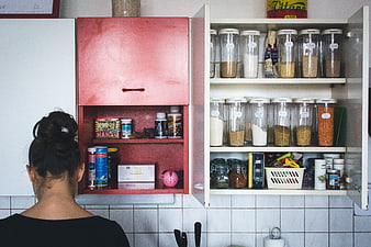 Woman looking at organized kitchen pantry shelves