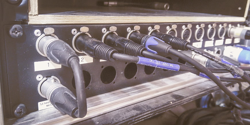Close-up of audio cables plugged into a mixing console
