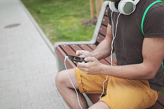 Man on Park Bench Using Smartphone with Headphones