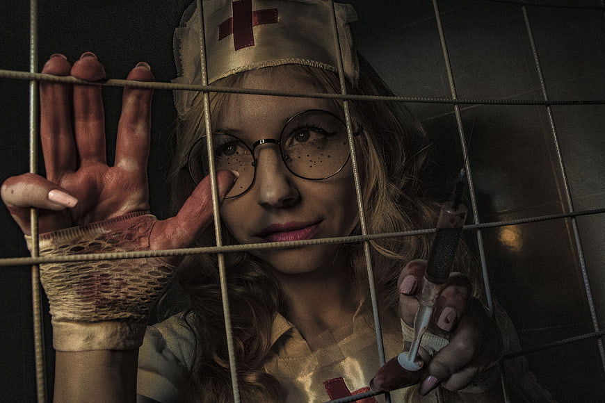 Horror Nurse Behind Bars Holding Syringe