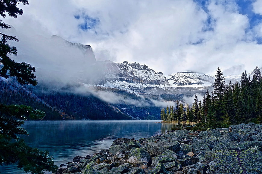Misty Mountain Lake with Rocky Shoreline and Pine Trees