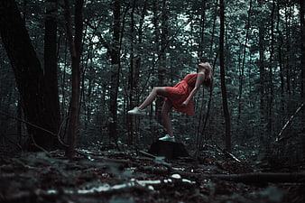 Woman in Red Dress Leaning Back in Dark Forest