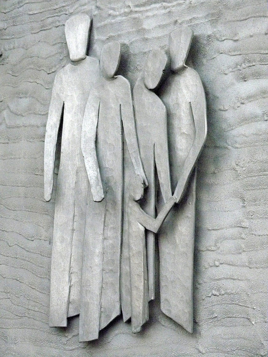 Modern metal relief sculpture of four abstract figures