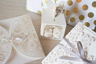 Elegant white laser-cut wedding favor boxes with gold polka dots