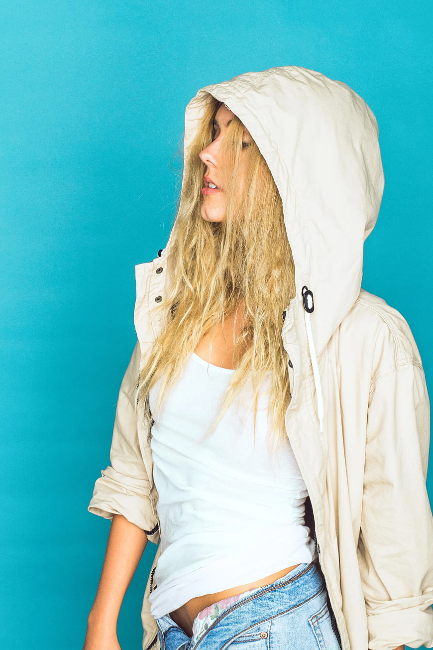 Blonde Woman in Hoodie Against Blue Background