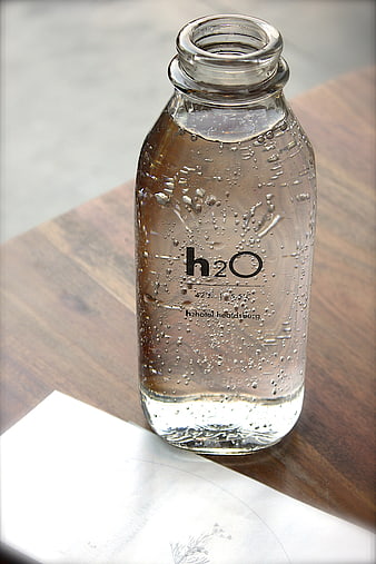 Glass Bottle of Sparkling Water on Wooden Table