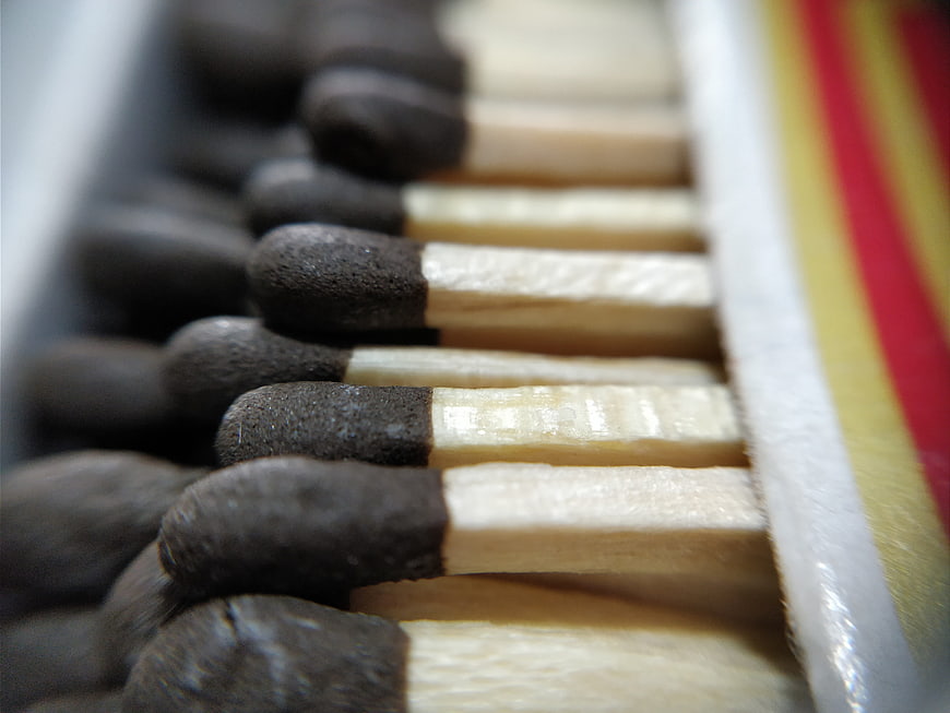 Close-up of matchsticks in a box with red and yellow stripes