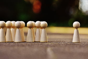 Wooden game pieces symbolizing one against all concept