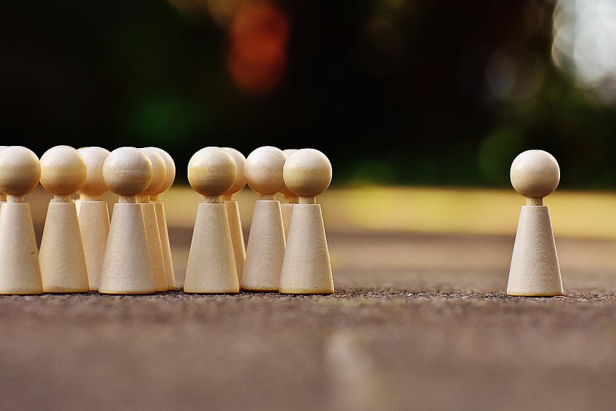 Wooden game pieces symbolizing one against all concept