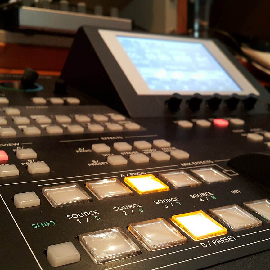 Close-up of professional video editing control surface with illuminated buttons