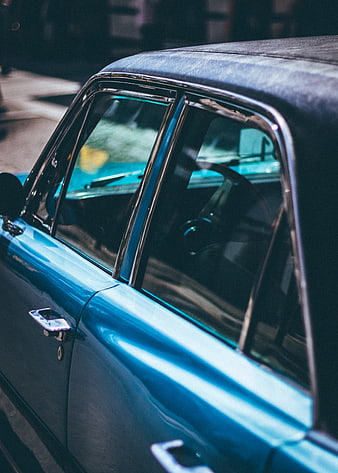 Close-up of vintage blue car side window and chrome trim