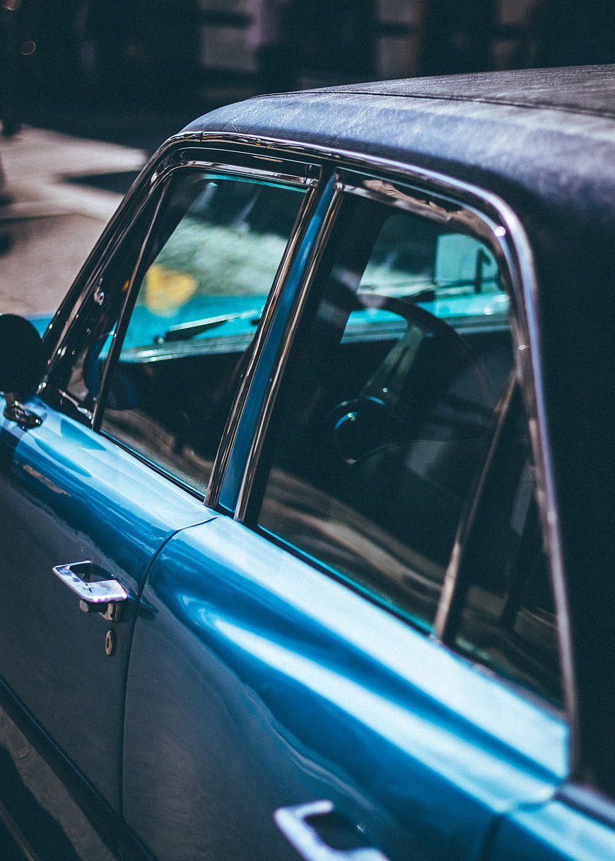 Close-up of vintage blue car side window and chrome trim
