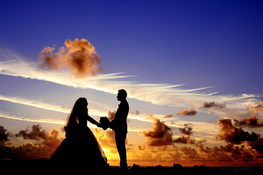 Silhouette of Bride and Groom Holding Hands at Sunset
