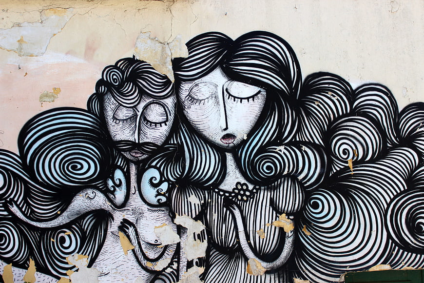 Black and white street art mural of couple with swirling hair
