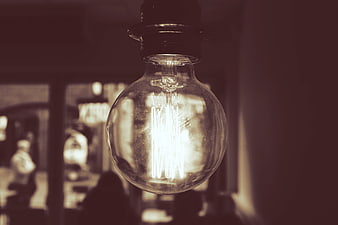 Vintage Edison light bulb glowing in a cozy cafe interior