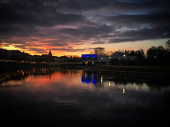 Dramatic Sunset Reflections on River with City Skyline
