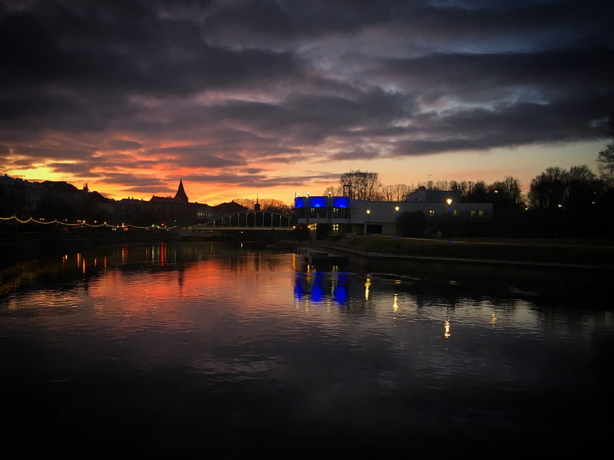 Dramatic Sunset Reflections on River with City Skyline