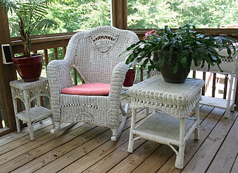 White Wicker Rocking Chair And Side Tables On Wooden Porch